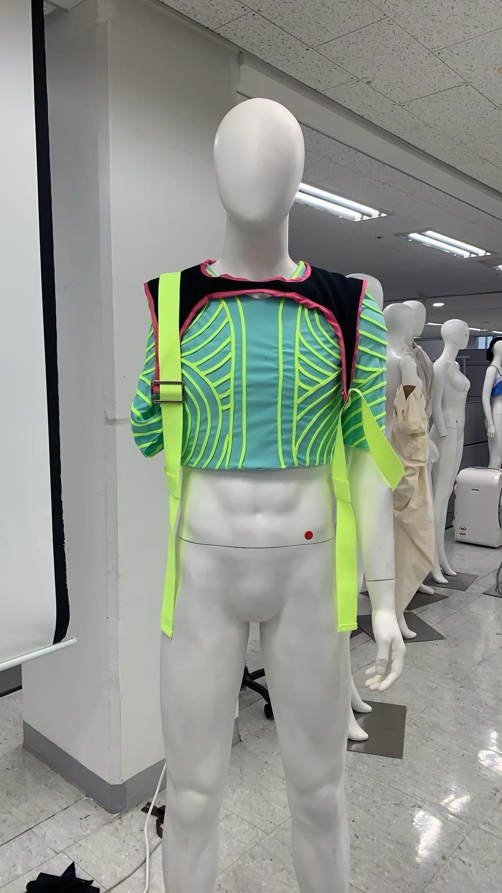 Quilted cyan crop top with lime piping and neon straps on a mannequin